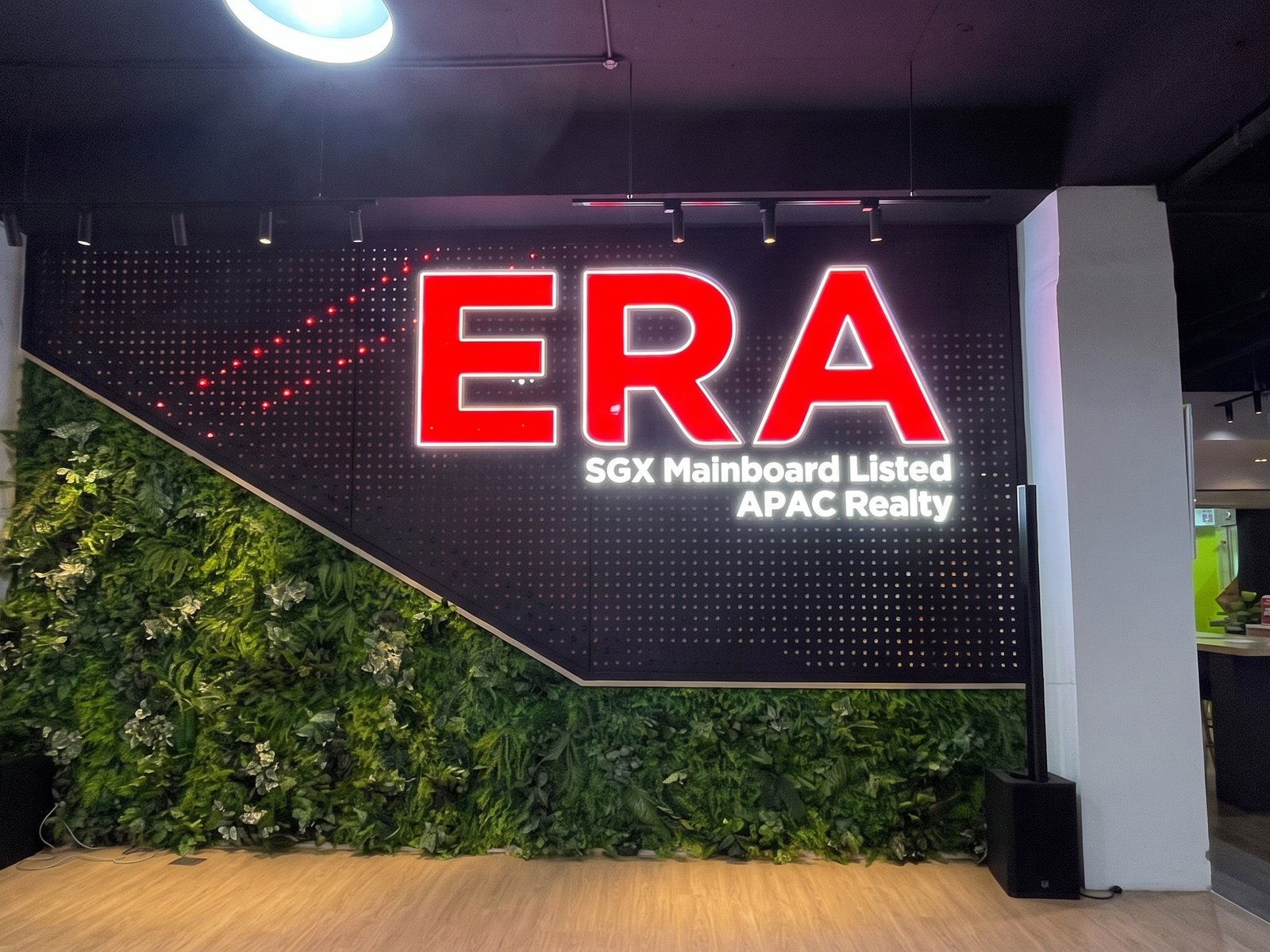 ERA · APAC Realty — illuminated letters · green wall