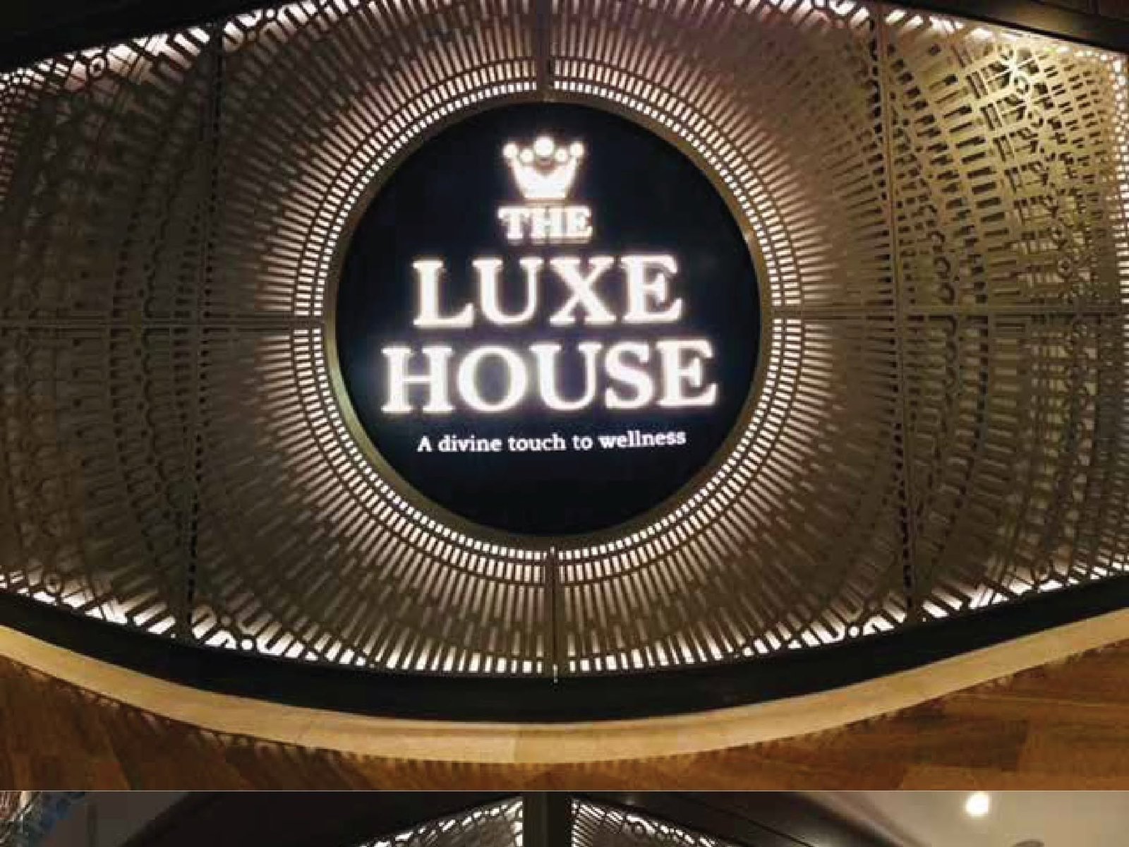 The Luxe House — illuminated lockup · facade screen